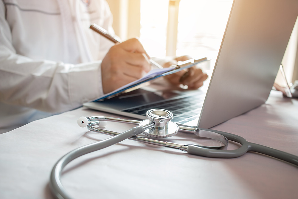 physician with computer and stethoscope